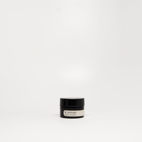 veologē Honey Lip Balm, ten-ingredient natural balm with real honey, shea butter, and rosehip oil for lips, cuticles, and eye area.
